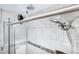 Close-up of a modern shower with glass doors and marble-style tiling at 5431 W Cochise Dr, Glendale, AZ 85302