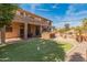 Expansive backyard view featuring putting green, outdoor kitchen, pool, and covered patio, perfect for entertaining and relaxing at 5917 N 133Rd Ave, Litchfield Park, AZ 85340