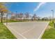 Community park basketball court surrounded by green grass, trees and walking paths on a sunny day at 5917 N 133Rd Ave, Litchfield Park, AZ 85340