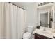 This bathroom features a shower with a white curtain, toilet, and a vanity sink at 5917 N 133Rd Ave, Litchfield Park, AZ 85340
