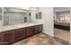 Bathroom with dual sinks, dark wood cabinets, tile floor, and neutral walls at 5917 N 133Rd Ave, Litchfield Park, AZ 85340