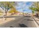 Gated community entrance with manicured landscape, mature trees and wrought iron gates at 5917 N 133Rd Ave, Litchfield Park, AZ 85340