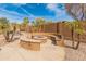 Inviting outdoor fire pit area with built-in seating and lush landscaping, perfect for cozy evenings and social gatherings at 5917 N 133Rd Ave, Litchfield Park, AZ 85340