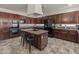 Well-equipped kitchen boasts dark wood cabinetry, granite countertops, and a functional center island at 5917 N 133Rd Ave, Litchfield Park, AZ 85340