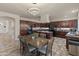 Large kitchen with dining space, modern chandelier, dark cabinets, granite countertops, and stainless steel appliances at 5917 N 133Rd Ave, Litchfield Park, AZ 85340