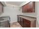 This laundry room includes appliances, storage and tiled floors at 5917 N 133Rd Ave, Litchfield Park, AZ 85340