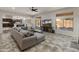 Open living room featuring large sectional sofa, tile flooring, and modern ceiling fan at 5917 N 133Rd Ave, Litchfield Park, AZ 85340