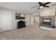 Primary bedroom featuring soft carpet, accent fireplace, and modern TV at 5917 N 133Rd Ave, Litchfield Park, AZ 85340