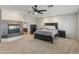 Primary bedroom featuring soft carpet, accent fireplace, and modern ceiling fan at 5917 N 133Rd Ave, Litchfield Park, AZ 85340
