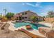 Inviting backyard oasis with a custom pool, spa, rock features, mature palms and desert landscaping at 5917 N 133Rd Ave, Litchfield Park, AZ 85340