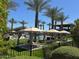 Inviting community pool area with private cabanas, lush landscaping, and plenty of seating for residents at 650 N Hawes Rd # 4609, Mesa, AZ 85207