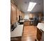 Efficient kitchen with a skylight, stainless steel appliances, light wood cabinets, and laminate flooring at 650 N Hawes Rd # 4609, Mesa, AZ 85207