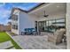 Spacious back patio features a cozy seating area, sliding glass doors and well manicured lawn at 6790 S Springs Pl, Chandler, AZ 85249