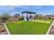 Beautiful artificial turf backyard with a modern pergola covered fire pit area and decorative landscaping at 6790 S Springs Pl, Chandler, AZ 85249