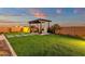 Beautiful backyard featuring a manicured lawn, stone walkway, and a covered outdoor fireplace at 6790 S Springs Pl, Chandler, AZ 85249