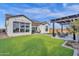 Expansive backyard view showcasing manicured lawn, modern fire pit area, and stylish home exterior at 6790 S Springs Pl, Chandler, AZ 85249