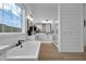 Bright and airy bathroom featuring wood-look floors, soaking tub, and frameless shower at 6790 S Springs Pl, Chandler, AZ 85249