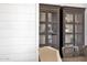 Dining room featuring built-in glass cabinets and shiplap walls at 6790 S Springs Pl, Chandler, AZ 85249