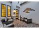 Enclosed outdoor sitting area with four chairs, decorative wall hanging and brick-paved patio at 6790 S Springs Pl, Chandler, AZ 85249