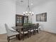 Elegant dining room with a long wood table, upholstered chairs, shiplap walls, and stylish chandelier at 6790 S Springs Pl, Chandler, AZ 85249