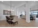 Open-concept dining room with a wood table, chandelier, and seamless flow into the living area at 6790 S Springs Pl, Chandler, AZ 85249