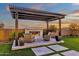 Charming outdoor fireplace under pergola with stone surround and cozy seating at 6790 S Springs Pl, Chandler, AZ 85249