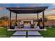 Outdoor fireplace under pergola with stone surround and comfortable seating at 6790 S Springs Pl, Chandler, AZ 85249