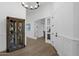 Hallway with glass doors, display cabinet, and light wood floors at 6790 S Springs Pl, Chandler, AZ 85249