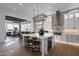Modern kitchen with a large island, stylish lighting, and an open view into the dining and living areas at 6790 S Springs Pl, Chandler, AZ 85249