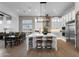 Open concept kitchen and dining featuring wood floors, dining table, modern light fixture, and large island at 6790 S Springs Pl, Chandler, AZ 85249