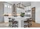 Bright kitchen boasts white cabinets, stainless steel appliances, large island with seating, and stylish brick backsplash at 6790 S Springs Pl, Chandler, AZ 85249
