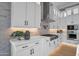 Modern kitchen features white cabinets, stainless steel appliances, quartz countertops, and a brick accent wall at 6790 S Springs Pl, Chandler, AZ 85249