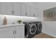 Laundry room with modern front load washer and dryer and white shaker cabinets at 6790 S Springs Pl, Chandler, AZ 85249