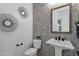 Charming powder room with patterned wallpaper, pedestal sink, and decorative mirror at 6790 S Springs Pl, Chandler, AZ 85249