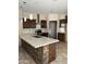 Modern kitchen features dark cabinets, stainless steel appliances, stone accents, and a large island at 7163 W Lamar Rd, Glendale, AZ 85303