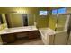 Bright bathroom with a dual sink vanity, separate shower, and bathtub with natural light at 7511 S 45Th Dr, Laveen, AZ 85339