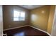 Comfortable bedroom with wood-look flooring, a window for natural light, and neutral-toned walls at 7511 S 45Th Dr, Laveen, AZ 85339
