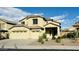 Two-story home featuring a three-car garage and a well-maintained, xeriscaped front yard, perfect for low-maintenance living at 7511 S 45Th Dr, Laveen, AZ 85339