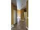 Hallway with tile flooring, doors, and neutral paint, providing a bright and transitional space at 7511 S 45Th Dr, Laveen, AZ 85339