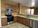 A spacious kitchen features wooden cabinets, stainless steel appliances, and light countertops at 7511 S 45Th Dr, Laveen, AZ 85339