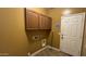 Practical laundry room with overhead cabinets, utility connections, and access to the exterior at 7511 S 45Th Dr, Laveen, AZ 85339