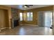Cozy living room with a stone fireplace, ceiling fan, and sliding glass doors for outdoor access at 7511 S 45Th Dr, Laveen, AZ 85339