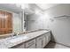 Bathroom with dual sinks set in a granite counter and white cabinets at 76 W Stacey Ln, Tempe, AZ 85284