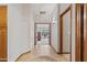 Welcoming hallway leads to various rooms, boasting tile flooring, wood trim, and warm lighting, offering a seamless flow at 76 W Stacey Ln, Tempe, AZ 85284