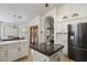 Open kitchen featuring an island with a dark countertop and stainless steel appliances at 76 W Stacey Ln, Tempe, AZ 85284