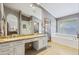 Bright bathroom with a large soaking tub, dual sink vanity, and a walk-in shower offering a spa-like experience at 76 W Stacey Ln, Tempe, AZ 85284