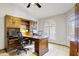 A home office with carpet flooring, an arched window, built-in shelves, and a large wooden desk at 76 W Stacey Ln, Tempe, AZ 85284