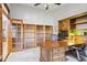 Spacious office with built-in shelves, wooden desk, carpet flooring, and glass paneled double doors at 76 W Stacey Ln, Tempe, AZ 85284