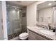 Modern bathroom featuring a marble countertop, gray cabinets, and a spacious glass-enclosed shower with dark stone accents at 7920 E Camelback Rd # 203, Scottsdale, AZ 85251