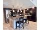 Contemporary kitchen features dark wood cabinets, stainless steel appliances, and a center island with seating at 7920 E Camelback Rd # 203, Scottsdale, AZ 85251